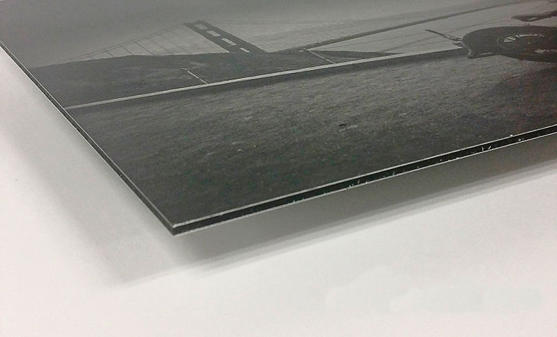 Impression sur m&eacute;tal en noir et blanc du Golden Gate Bridge montrant la surface d&rsquo;aluminium bross&eacute; qui transpara&icirc;t &agrave; travers les tons plus clairs