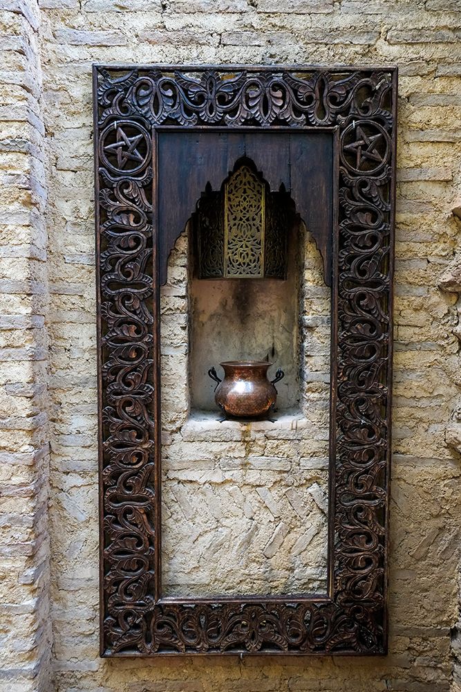 Fes-Morocco Old copper pot sits on a ledge with a carved wooden frame art print by Julien McRoberts for $57.95 CAD