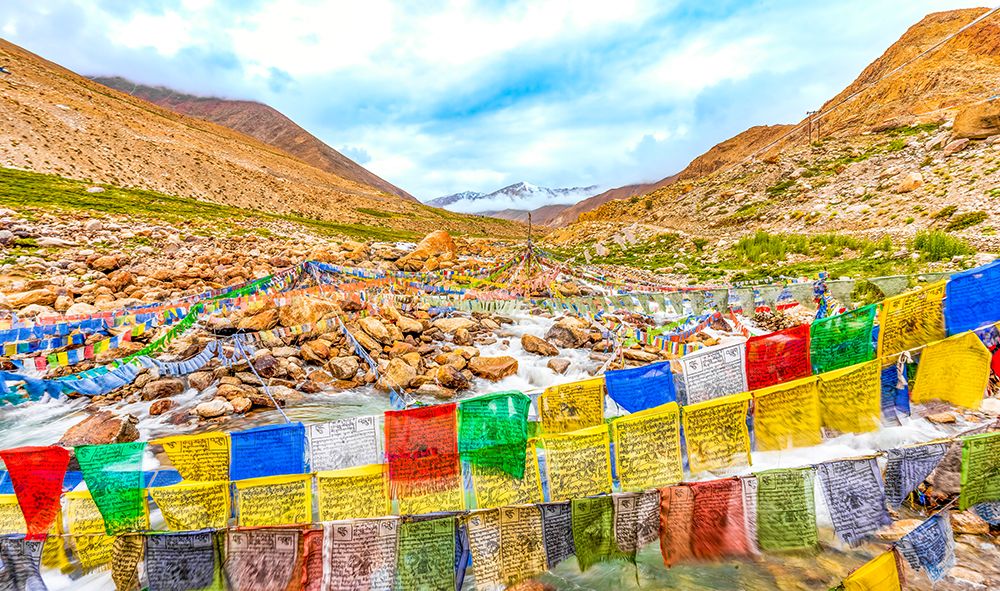 Ladakh, India. Mountain river rushing under prayer flags down from the Himalayan Mountains. art print by Murray McCallum for $57.95 CAD