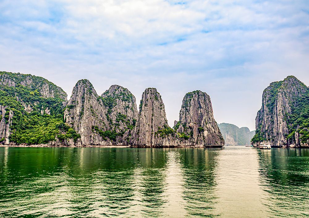 Ha Long Bay, Vietnam. Tourist boat cruising among limestone karsts and islets in turquoise waters. art print by Murray McCallum for $57.95 CAD