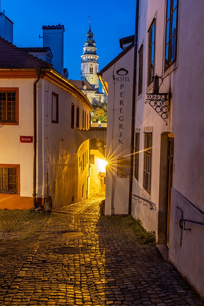 Narrow cobblestone streets at dusk with Castle Tower in historic Cesky Krumlov-Czech Republic. art print by Chuck Haney for $57.95 CAD