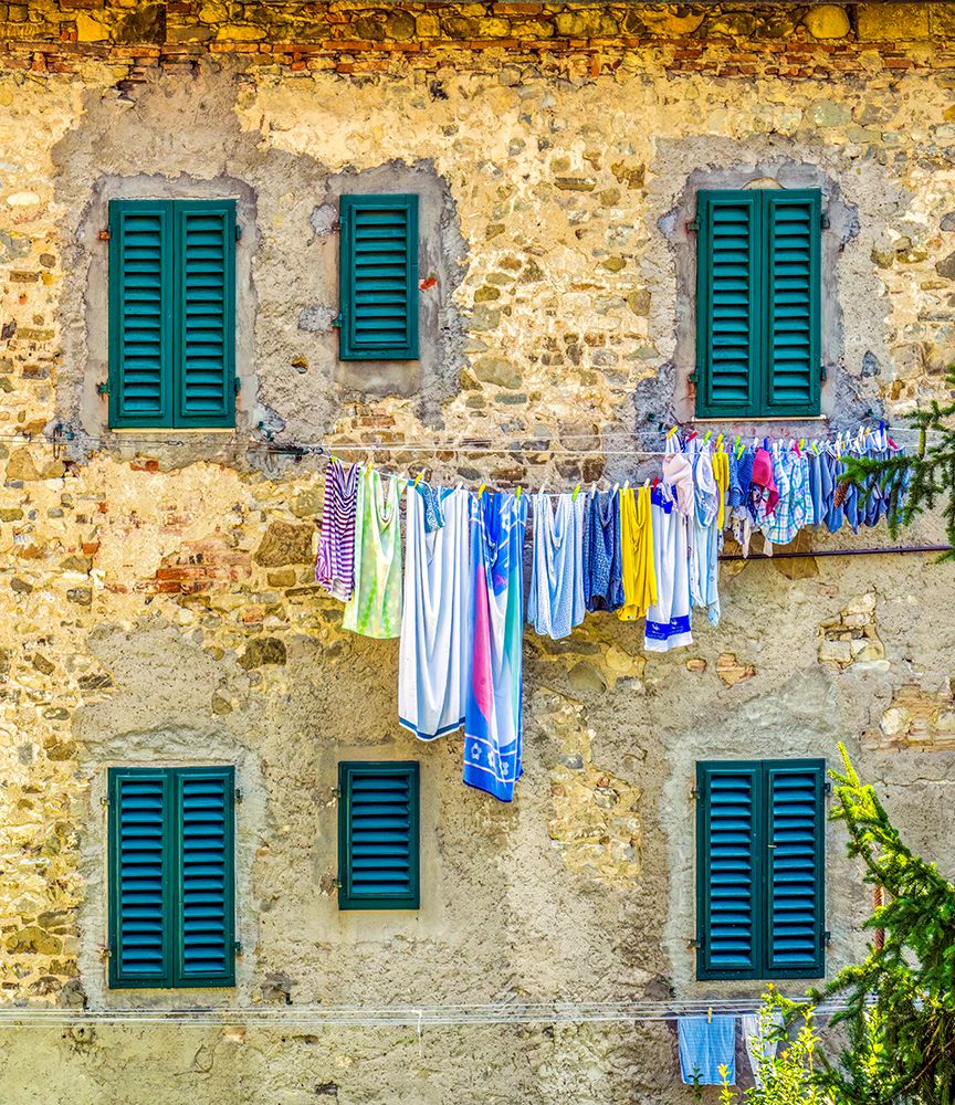 Greve in Chianti, Tuscany, Italy. Laundry hanging against a stone wall with green shuttered windows art print by Murray McCallum for $57.95 CAD