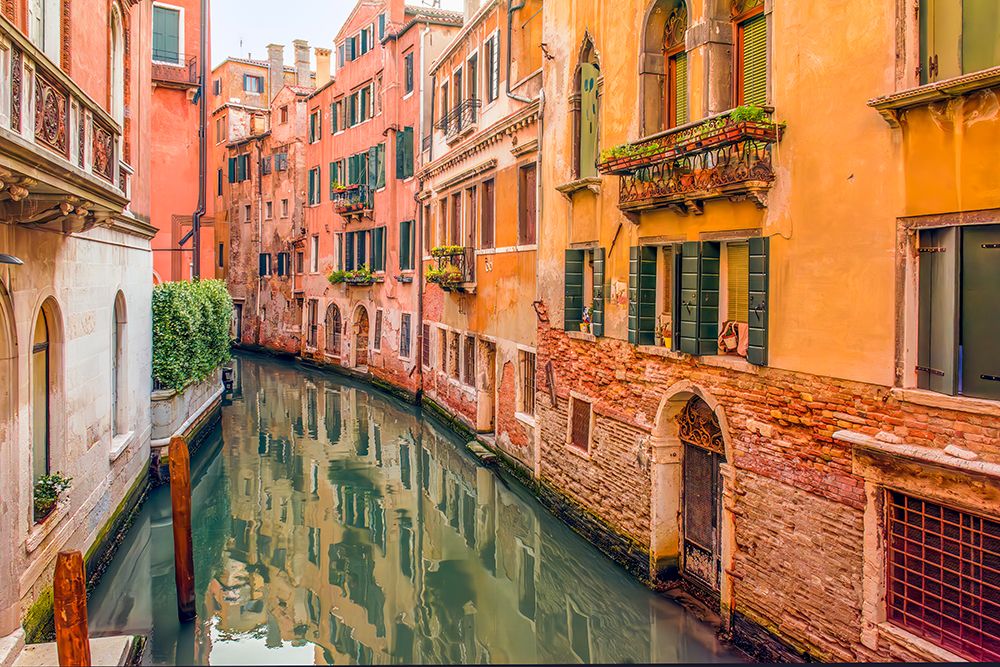 Canal, Venice, Italy. Wide angle view of the colorful, medieval buildings reflecting in the canal. art print by Murray McCallum for $57.95 CAD