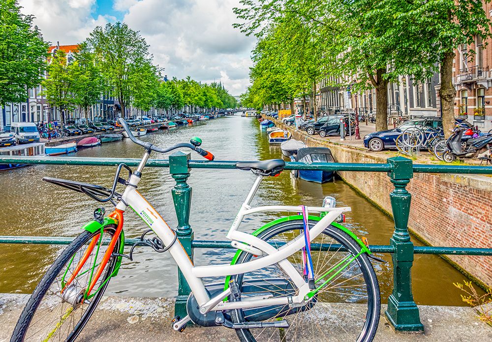 Amsterdam, Netherlands. brightly painted bicycle locked to a bridge crossing the canal. art print by Murray McCallum for $57.95 CAD