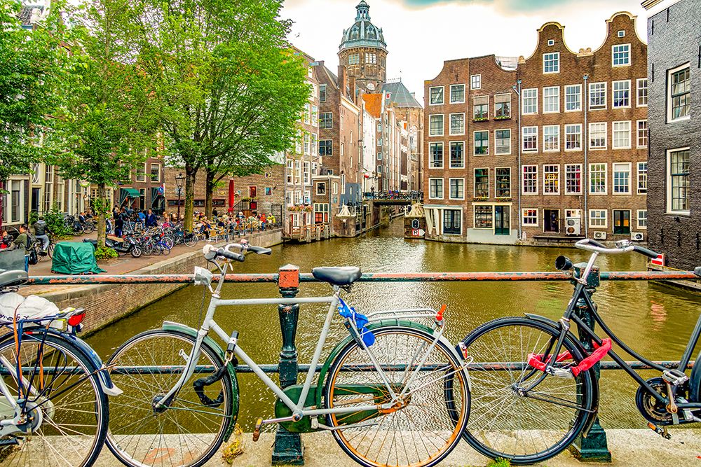 Amsterdam, Netherlands. two canals merging to form a corner for historical buildings. art print by Murray McCallum for $57.95 CAD