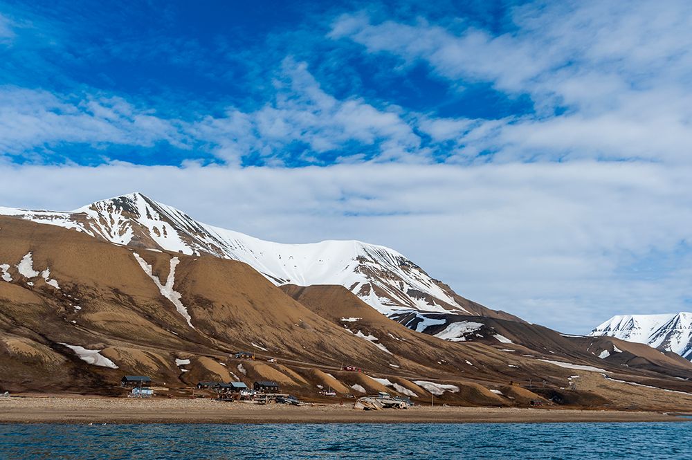 Snowy cliffs rise behind a small settlement on the bay of Adventfjorden Spitsbergen Island-Norway art print by Sergio Pitamitz for $57.95 CAD