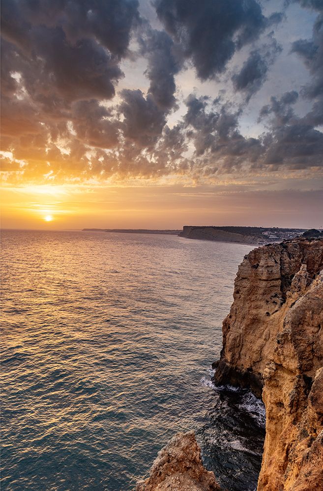 Dramatic sunset clouds over Cliffs along the coast at Ponta da Piedade in Lagos-Portugal art print by Chuck Haney for $57.95 CAD