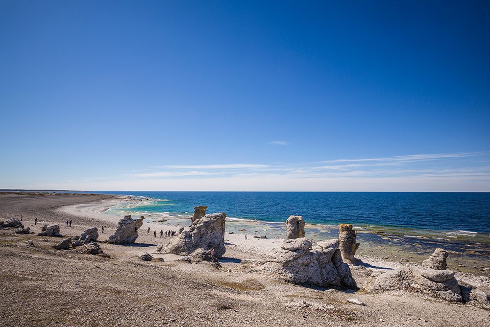 Sweden-Faro Island-Langhammars Area-Langhammar coastal limestone rauk rocks with visitors art print by Walter Bibikow for $57.95 CAD