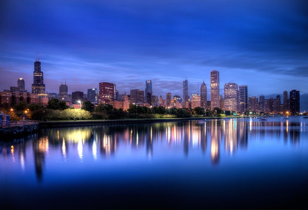 Chicago skyline reflects in lake Michigan during a blue sunrise art print by Steve Mohlenkamp for $57.95 CAD