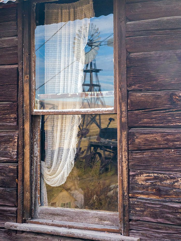 Reflection of the windmill and tractor in the window of an old building in ghost town. art print by Julie Eggers for $57.95 CAD