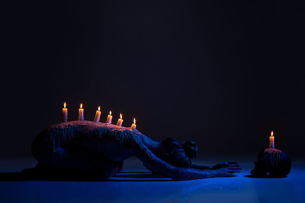 Burning Candles On Back Of Lady Bowing Down In Darkness art print by Andrey Guryanov for $57.95 CAD