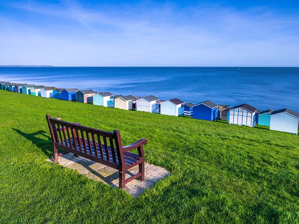 Bench on lawn with beach huts in background art print by Assaf Frank for $57.95 CAD