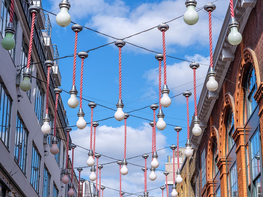 Light bulbs hanging across the buildings for Christmas decorations, London art print by Assaf Frank for $57.95 CAD