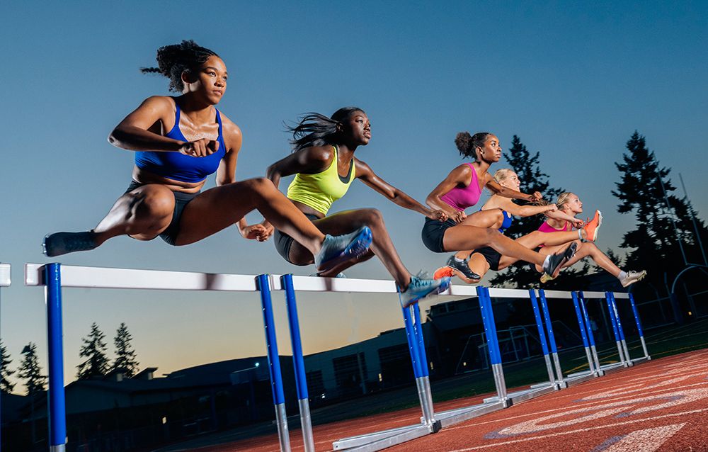 Athletes Race Over Hurdles On A Track At Dusk, Displaying Strength And Determination. Wa, USA art print by Pete Saloutos for $57.95 CAD