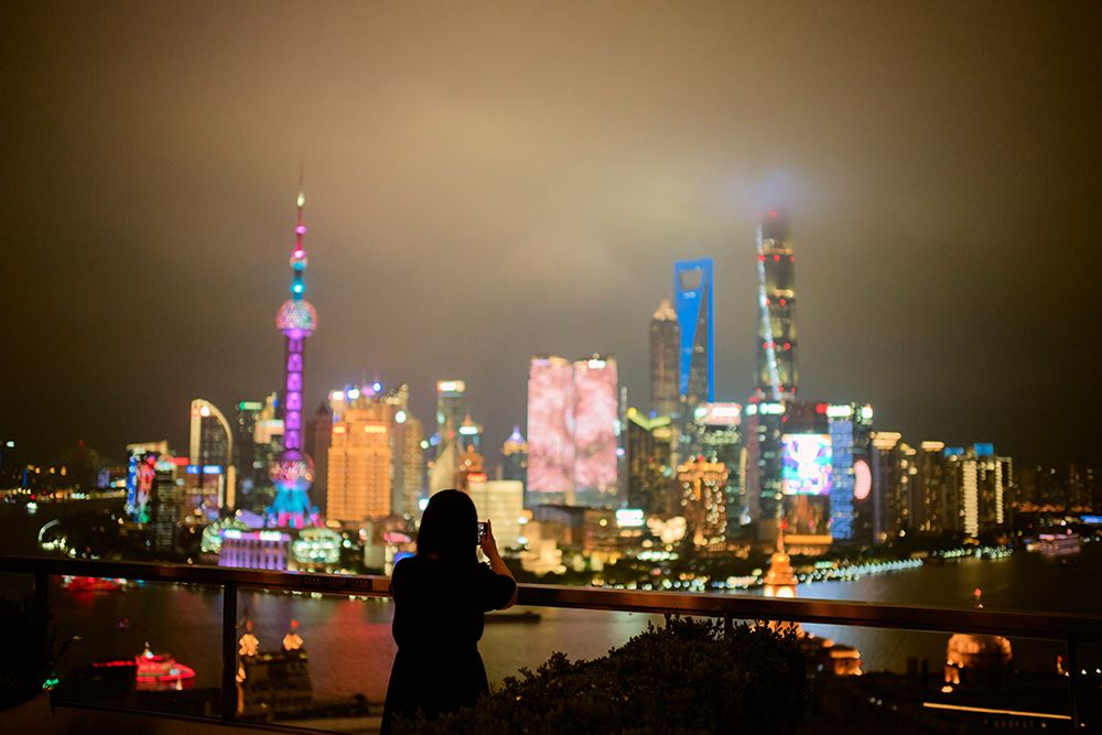 A Person Silhouetted Against A Vibrant City Skyline At Night With Colorful Lights. Shanghai, China art print by LB Studios for $57.95 CAD