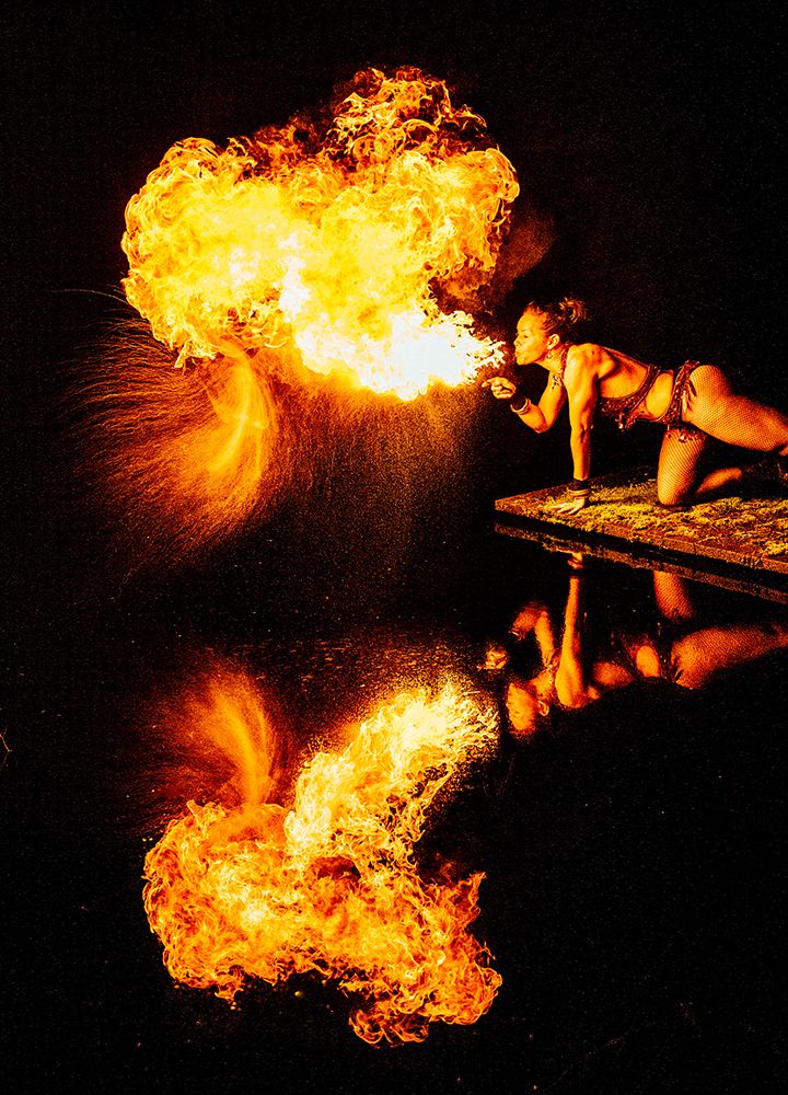 A Performer Breathes Fire, Creating A Dramatic Reflection On The Dark Water Surface. Wa, USA art print by Pete Saloutos for $57.95 CAD