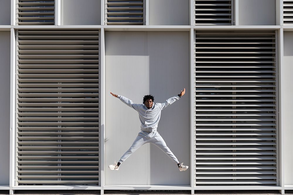Man Jumping In Front Of Modern Urban Building In Barcelona art print by Pau Cardellach Lliso for $57.95 CAD