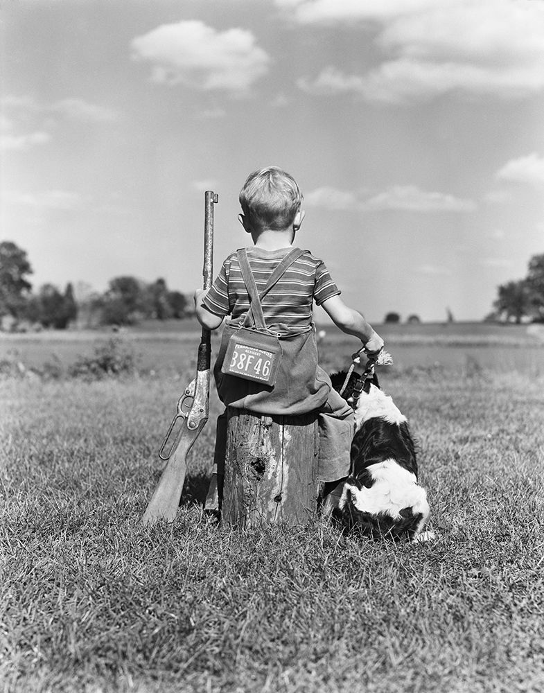 1940S Back View Of Boy Wearing Hunting Permit Holding Bb Gun Sitting On Tree Stump Next To Dog art print by ClassicStock for $57.95 CAD
