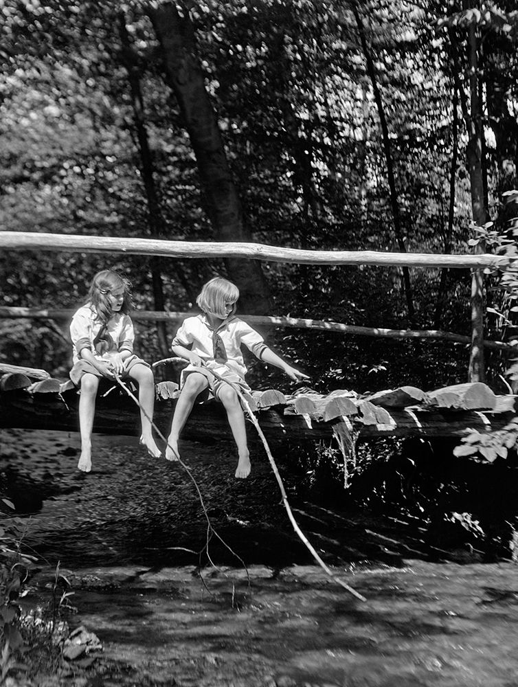 1920S Pair Of Girls Sitting On Log Bridge Over Stream Holding Sticks art print by ClassicStock for $57.95 CAD