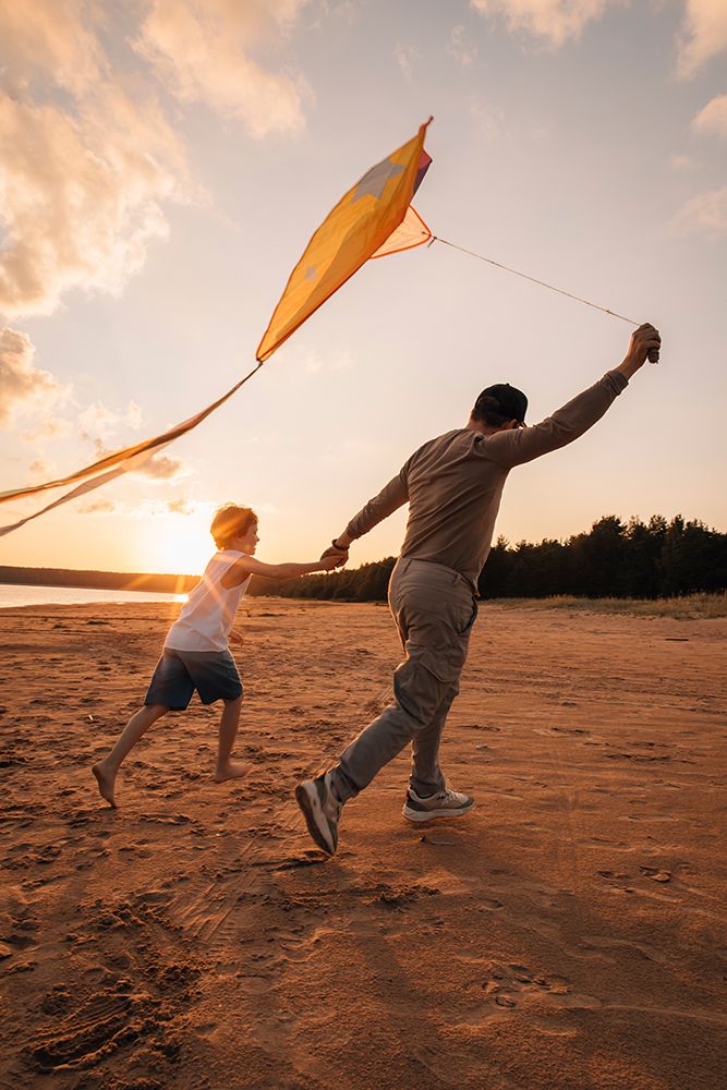 Father And Son Running With Kite On Beach At Golden Hour art print by Kseniia Liubasova for $57.95 CAD