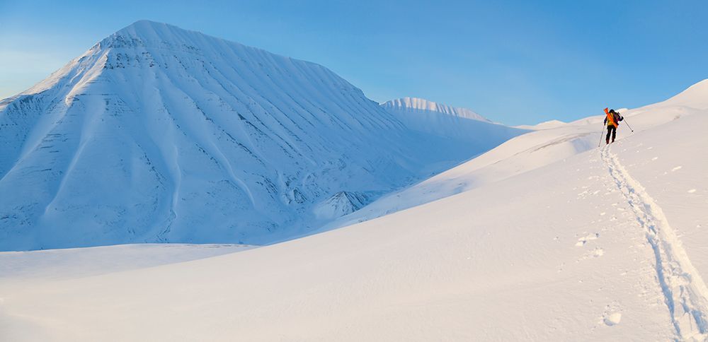 A Backcountry Skier Skins Up A Hillside In Kosladalen, Svalbard. art print by Ethan Welty for $57.95 CAD