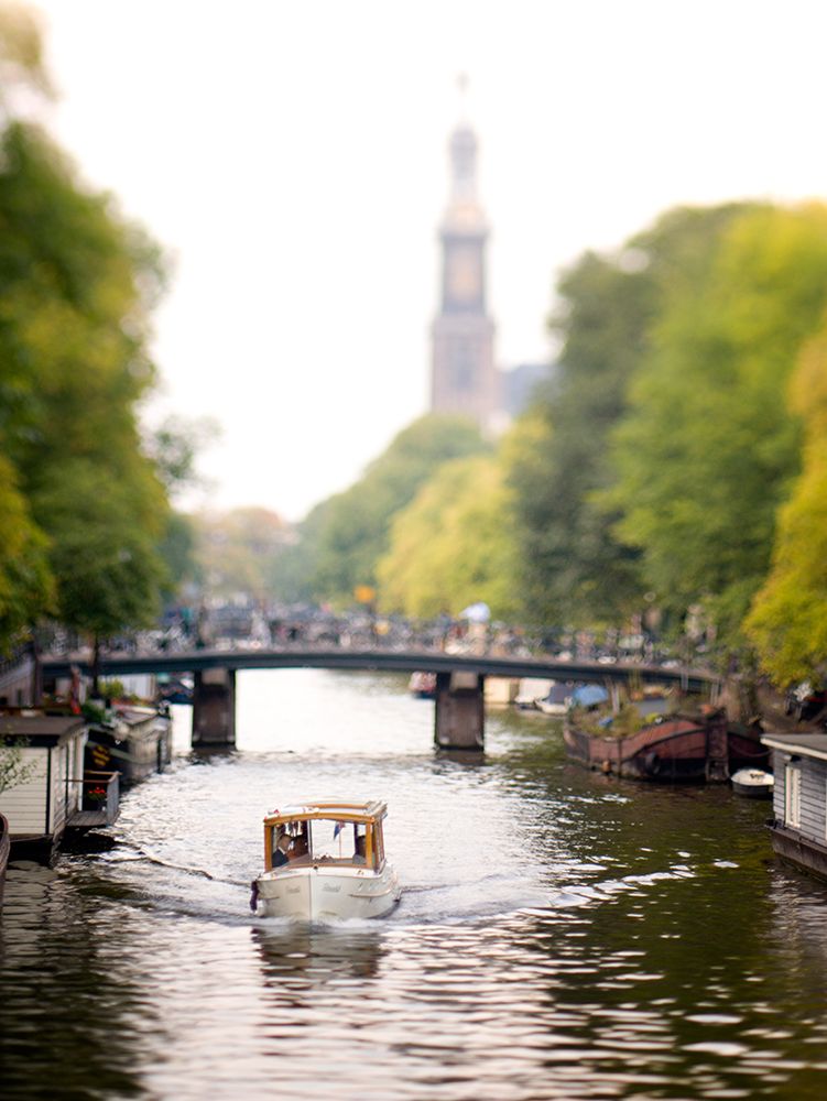 A Small Boat Moves Along A Canal In Amsterdam, The Netherlands (Holland). art print by Kevin Steele for $57.95 CAD