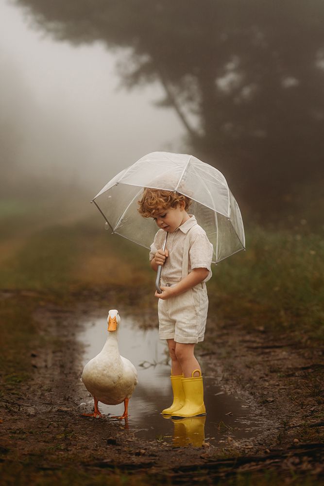 Little Boy In The Rain Hodling A Umbrella Witha White Duck art print by Andrea Martin for $57.95 CAD