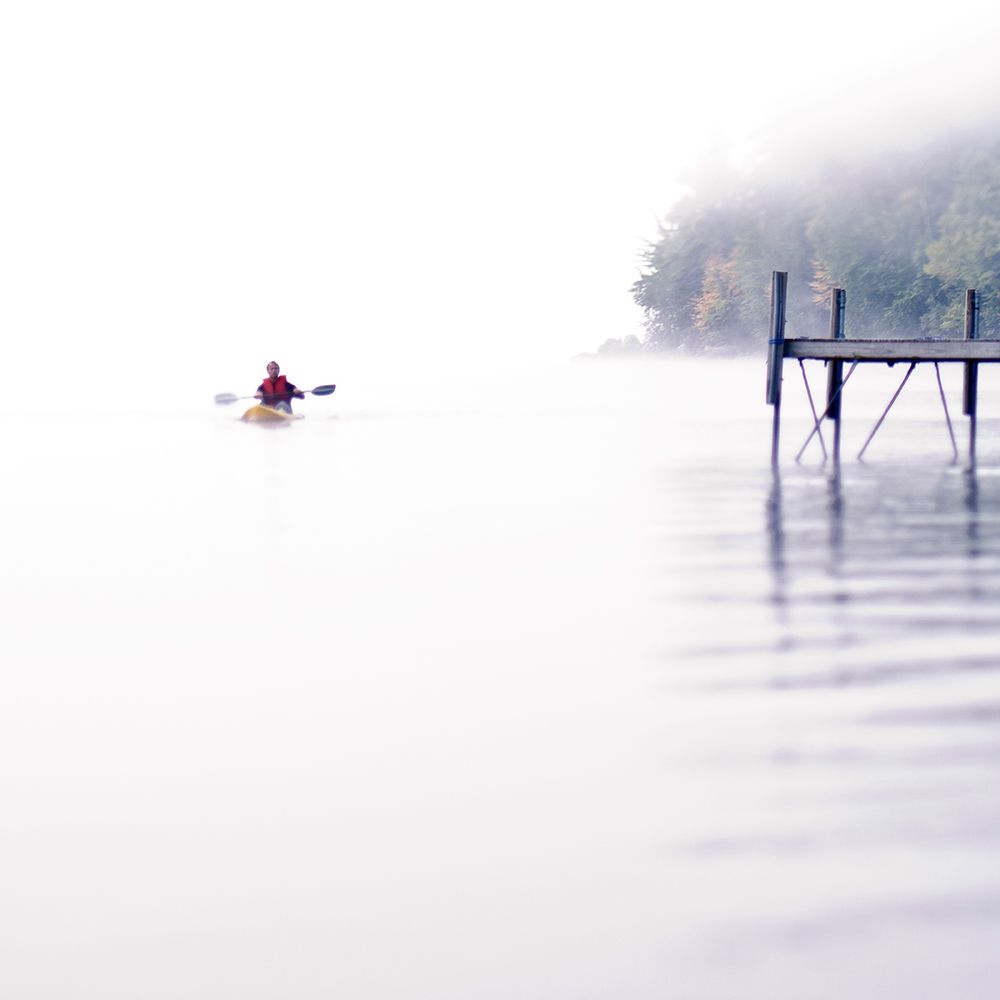 Man Paddles A Kayak Near A Dock On Lake Sebago Near Portland, Maine (Hi-Key) art print by Kevin Steele for $57.95 CAD