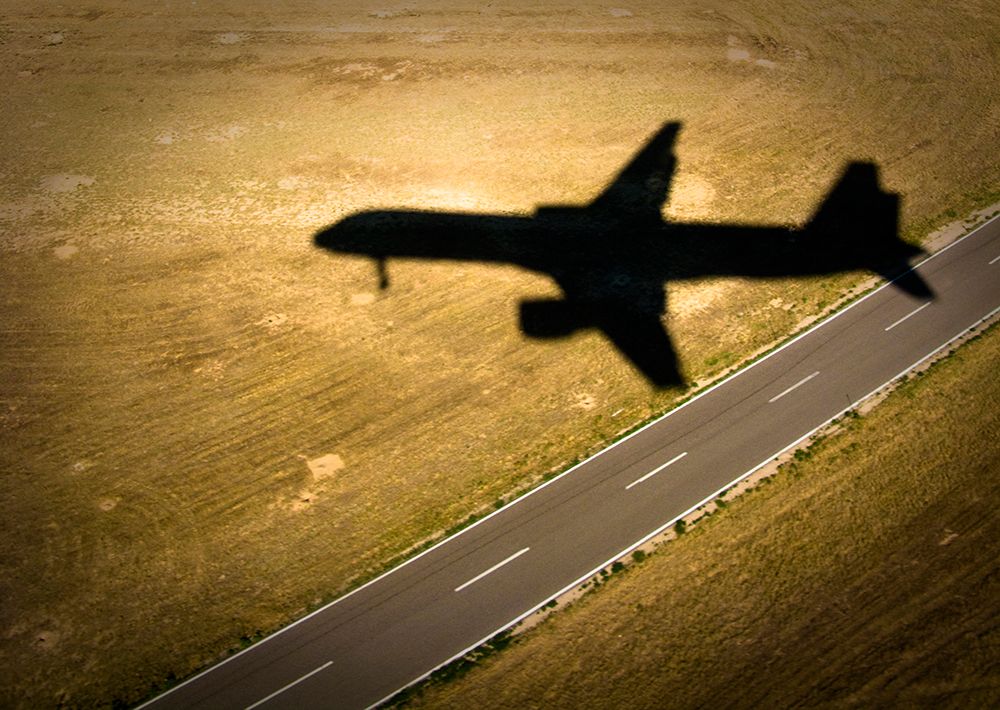 The Shadow Of An Airliner Crosses An Empty Road As It Approaches The Runway. art print by Kevin Steele for $57.95 CAD
