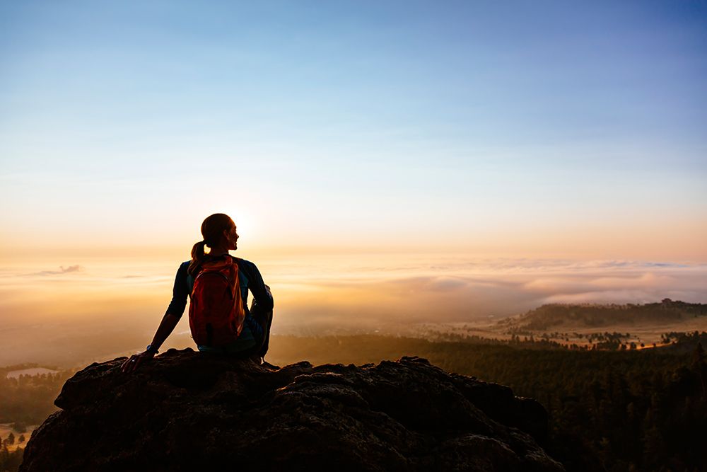 Woman Looking At Sunrise Sitting On Boulder In Colorado, USA art print by Andrew Peacock for $57.95 CAD