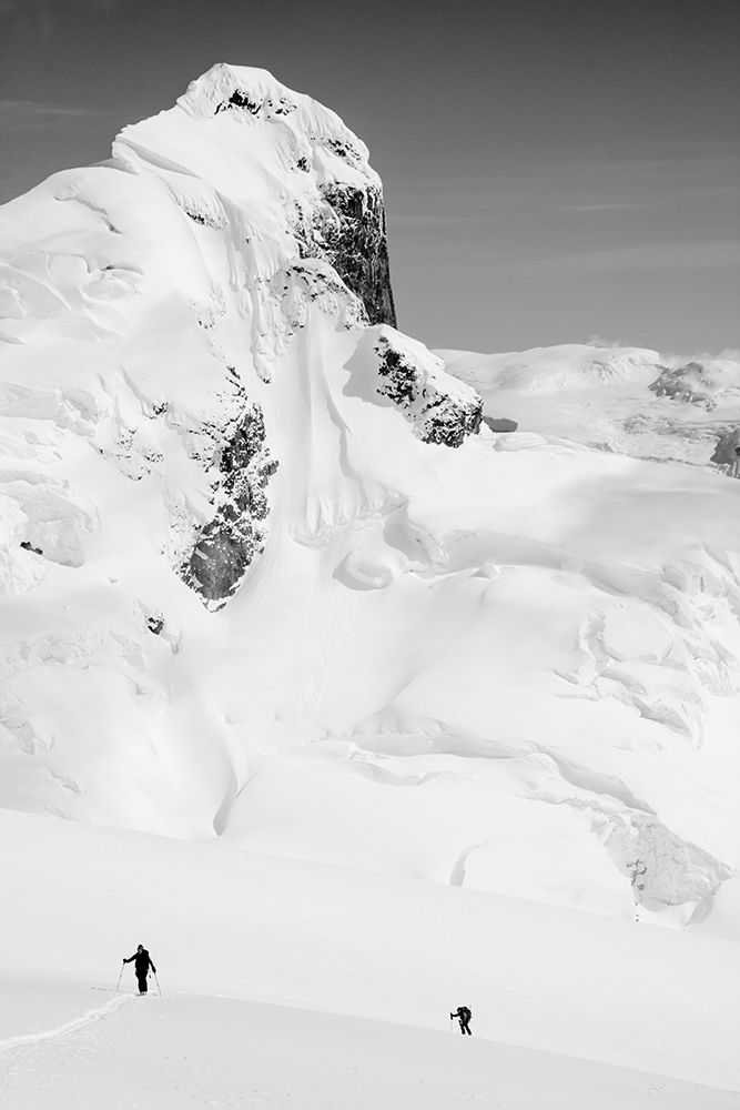 Two Skiers Near Base Of Large Snow Covered Mountain. art print by Gabe Rogel for $57.95 CAD