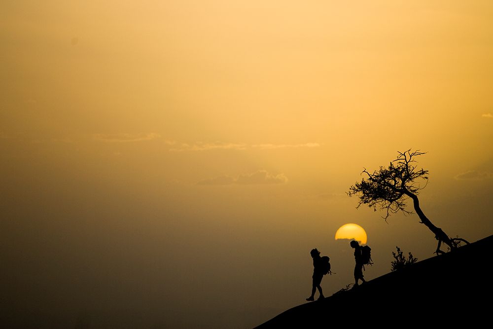 Females Walking With Backpacks As The Sun Sets In Africa art print by Gabe Rogel for $57.95 CAD