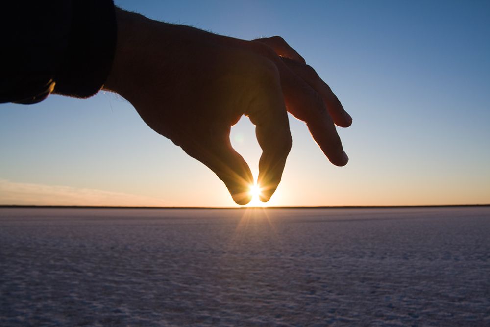 A Hand Pinches The Setting Sun Over The Salt Flats On Laguna San Ignacio, Baja California, Mexico. art print by Ethan Welty for $57.95 CAD