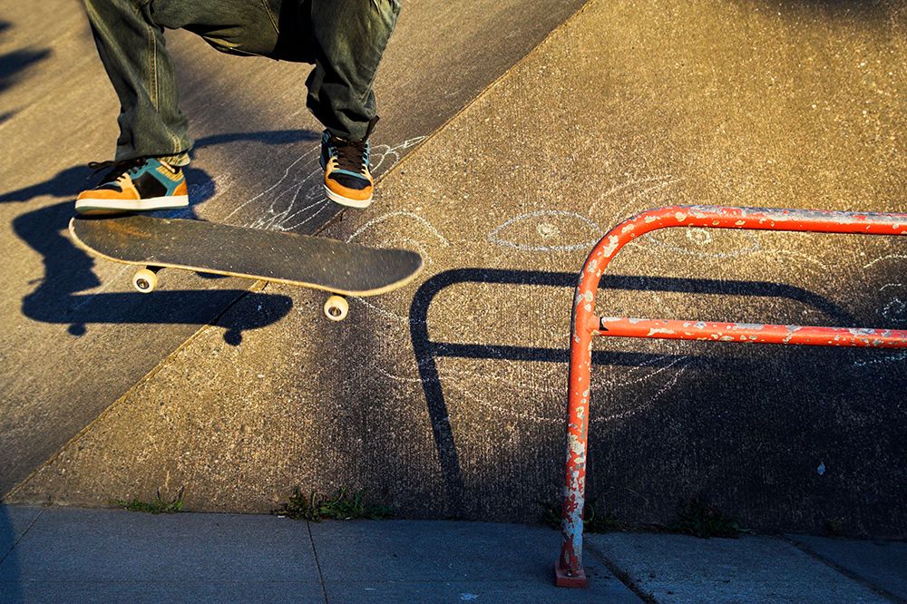 Skateboarder Wearing Colorful Shoes Jumps Off A Red Rail Outside A Pool, With Only The Legs Visible. art print by Ethan Welty for $57.95 CAD
