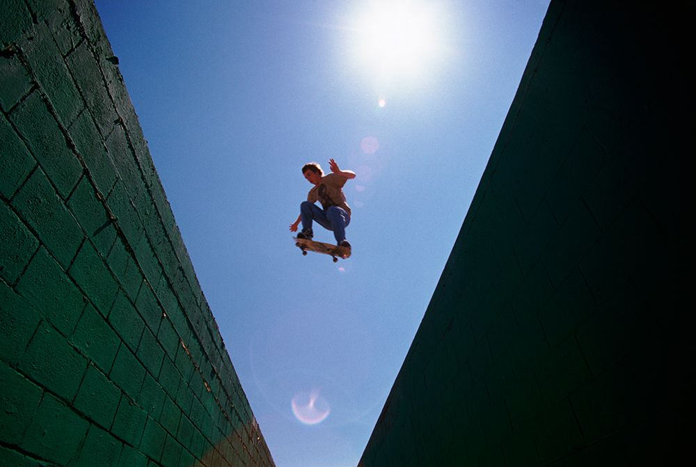 Backlit Skateboarder Airs Over A Roof To Roof Gap. art print by Dustin Miller for $57.95 CAD