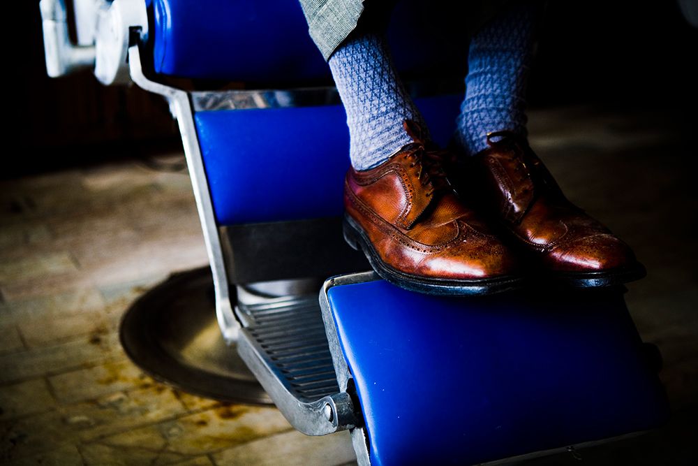 A Barber Rests His Shoes On The Barber Chair In Tijuana, Bc, Mexico. art print by Jay Reilly for $57.95 CAD
