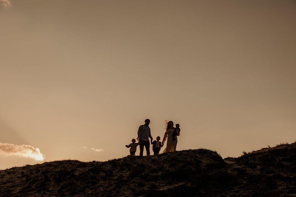 Silhouetted Family Walking Along A Dune Ridge At Sunset art print by Kiri for $57.95 CAD