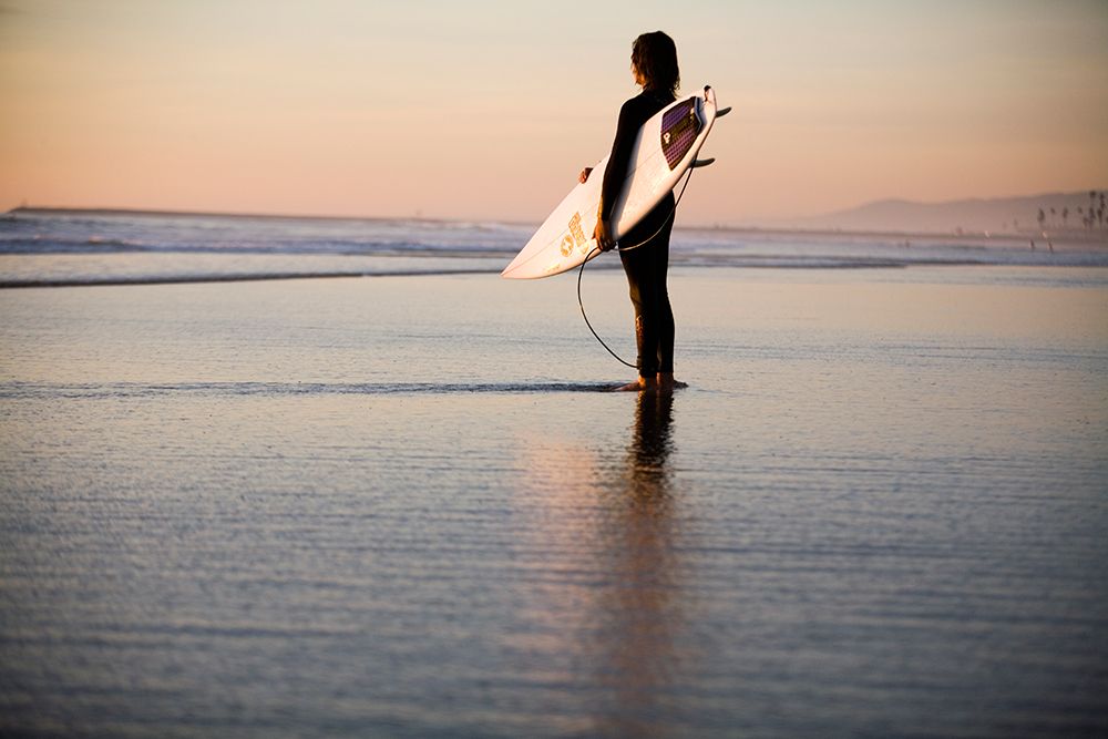 Surfer Stands On The Beach And Looks Out At The Sunset In Oceanside, Ca. art print by Jay Reilly for $57.95 CAD