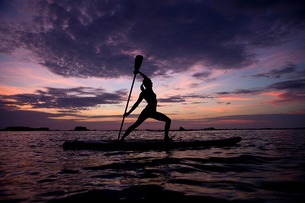 A Young Woman Streches On A Surf Board During A Yoga Lesson art print by Mauricio Ramos for $57.95 CAD