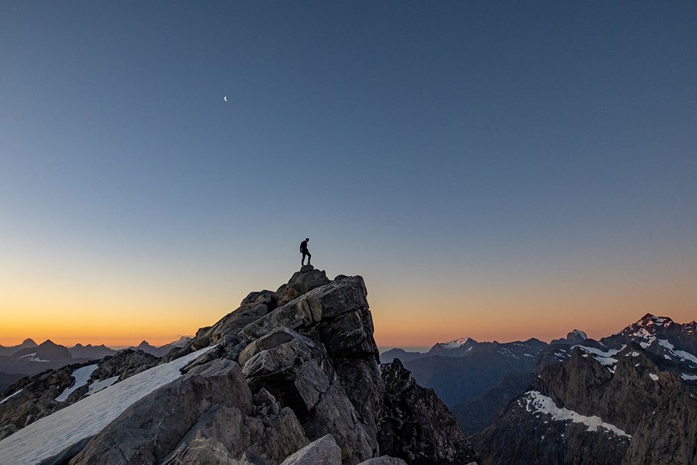 Conquer New Heights: Solo Hiker Reaches Mountain Summit At Sunrise - Adventure Travel Inspiration art print by Max Seigal for $57.95 CAD