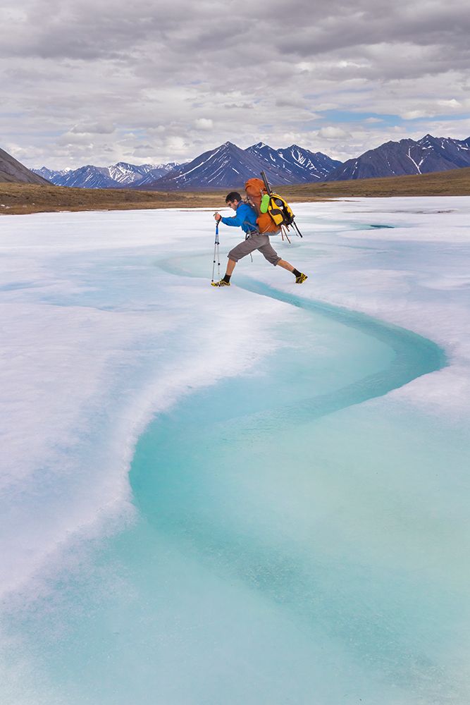 Backpacker Steps Over Water Melting On Aufeis Of Ribdon River In Arctic National Wildlife Alaska. art print by Patrick J Endres for $57.95 CAD