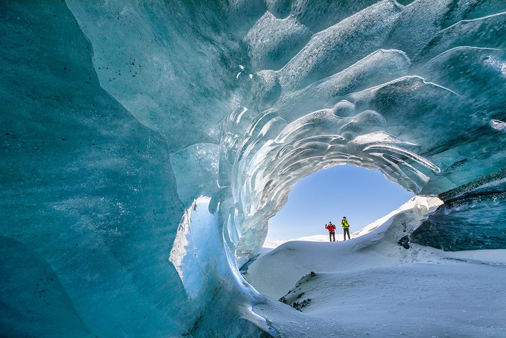 Two Cross Country Skiers Peer Into Glacier Ice Cave Formed By Melting Water Under Glacier Mountains. art print by Patrick J Endres for $57.95 CAD