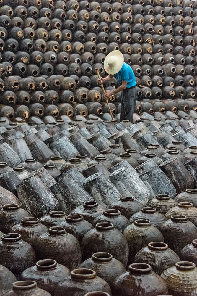 Man in the middle of big pile of wine jars-Wuxi-Jiangsu Province-China art print by Keren Su for $57.95 CAD