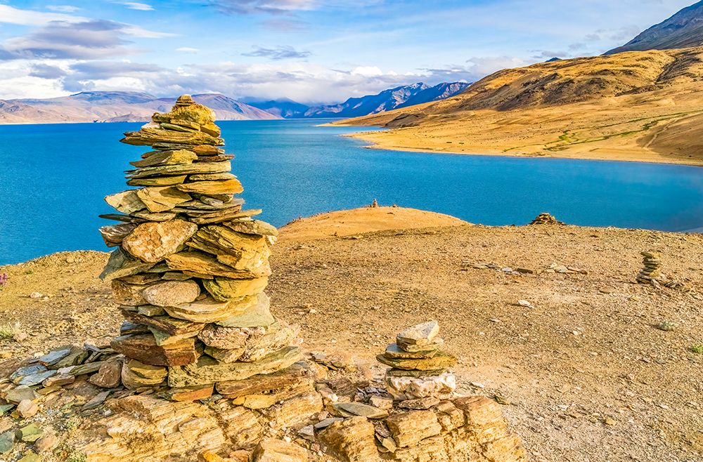 Lake, Ladakh, India. Stone cairns overlooking high altitude lake with Himalaya Mountains. art print by Murray McCallum for $57.95 CAD