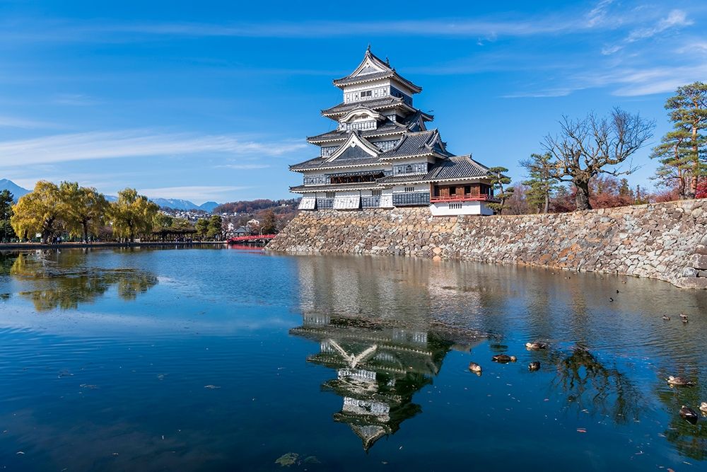 The Matsumoto Castle with reflection in the moat with bridge-walkway and mountains behind-Japan art print by Sheila Haddad for $57.95 CAD