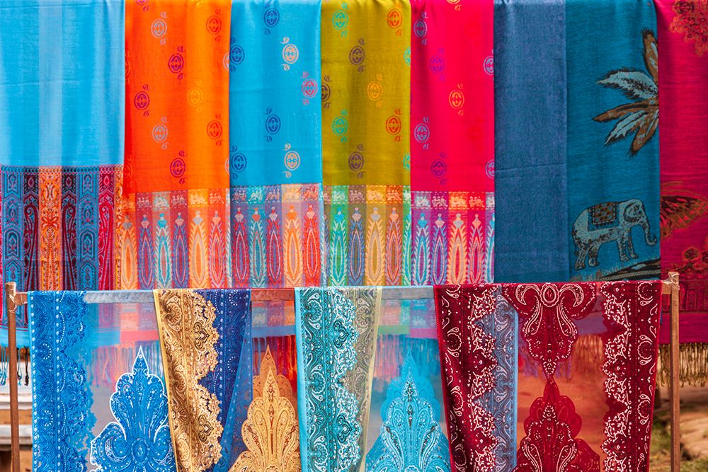 Laos- Luang Prabang. Colorful textiles- possibly scarves- for sale. art print by Tom Haseltine for $57.95 CAD