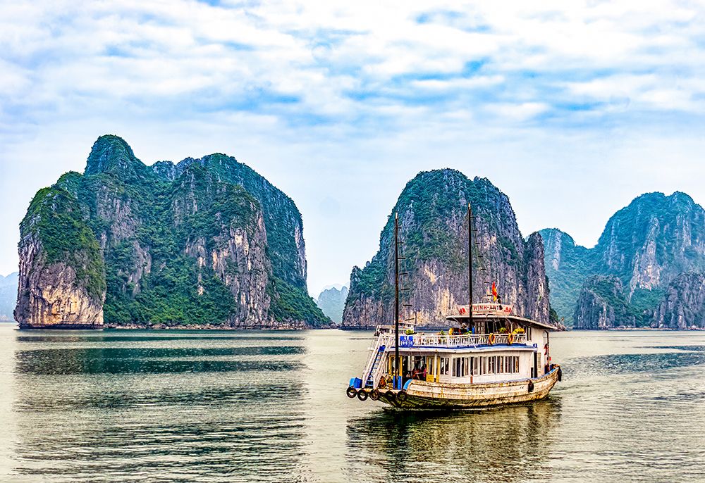 Ha Long Bay, Vietnam. Tourist boat cruising among limestone karsts and islets in UNESCO Site. art print by Murray McCallum for $57.95 CAD