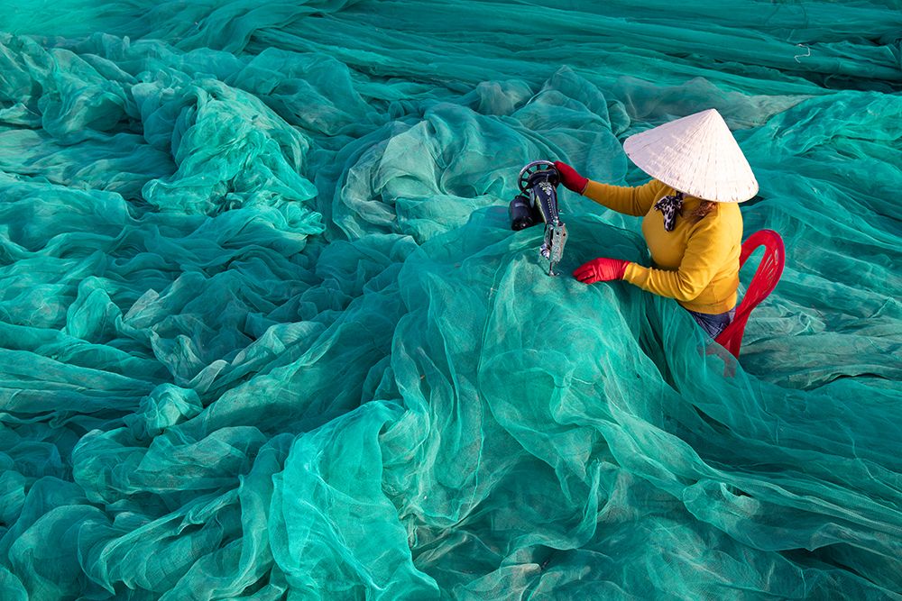 Vietnam-Fishing net analysis and repair with old fashioned manual sowing machine art print by Tom Norring for $57.95 CAD