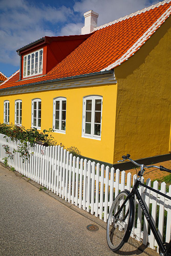 Skagen, Denmark. Bike, yellow house with white picket fence and terra cotta roof. art print by Jolly Sienda for $57.95 CAD