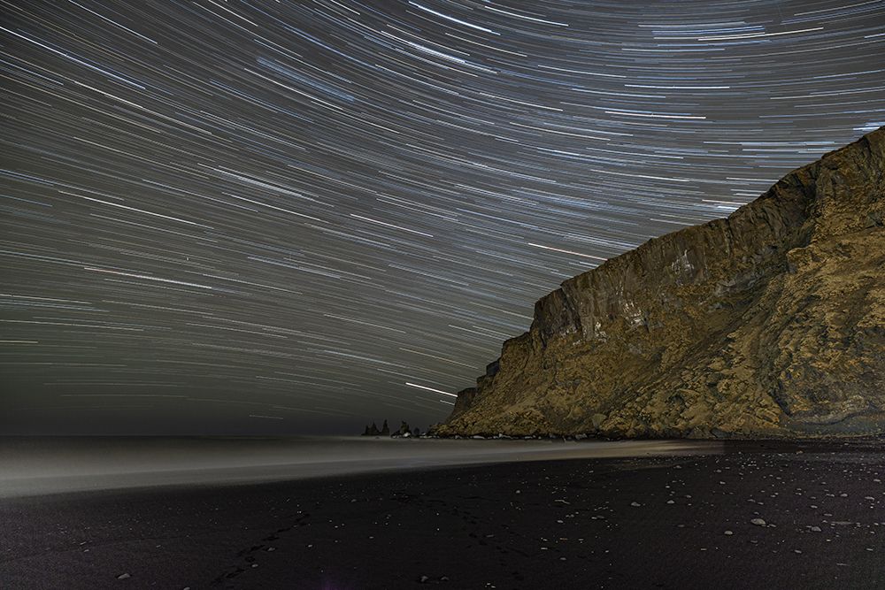 Iceland, Vik. Myrdal. Star trails above Reynisfjara black sand beach at night art print by Hollice Looney for $57.95 CAD